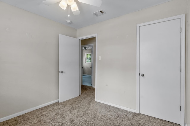 unfurnished bedroom featuring visible vents, a ceiling fan, carpet, and baseboards