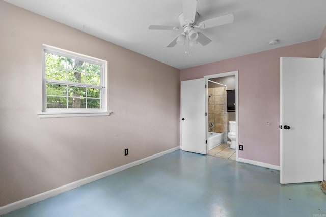 unfurnished bedroom with baseboards, a ceiling fan, concrete flooring, and ensuite bath