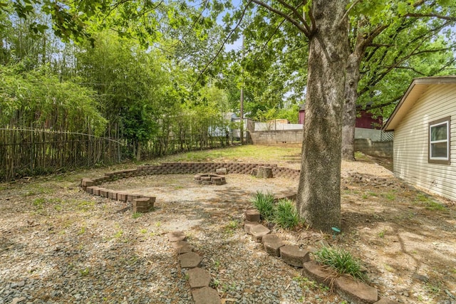 view of yard featuring a fire pit and a fenced backyard