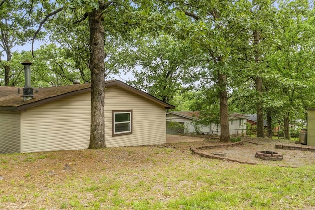 rear view of property featuring fence and an outdoor fire pit