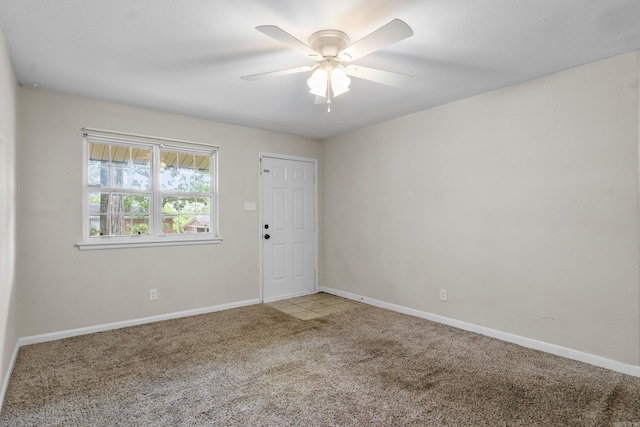 empty room with baseboards, ceiling fan, and carpet