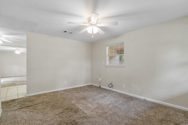 carpeted empty room featuring baseboards, a ceiling fan, and visible vents