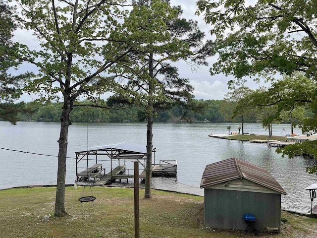 dock area with a water view and a view of trees