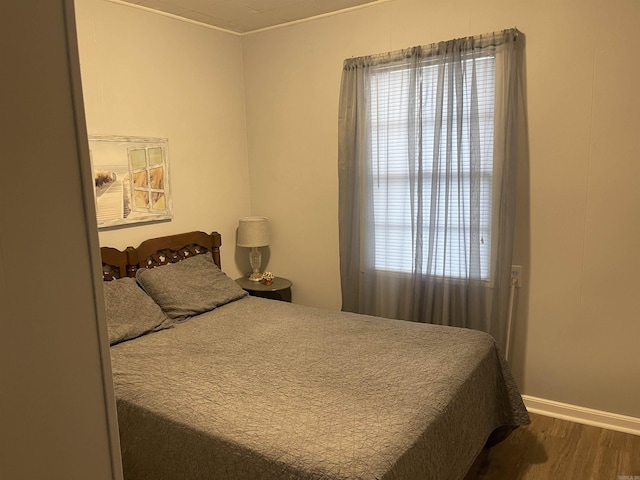 bedroom featuring baseboards and wood finished floors