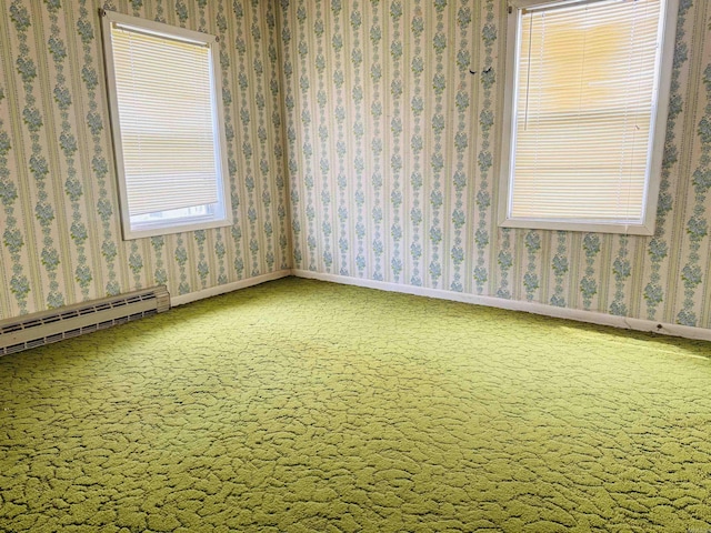 carpeted spare room featuring baseboards and a baseboard heating unit