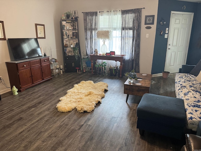 living room featuring baseboards and dark wood-type flooring