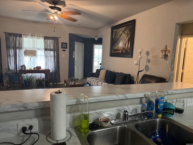 kitchen featuring a ceiling fan and a sink