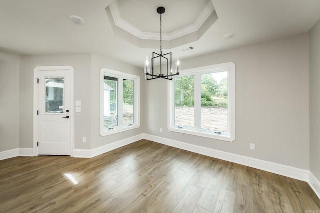 unfurnished dining area with visible vents, baseboards, dark wood-type flooring, a raised ceiling, and a chandelier