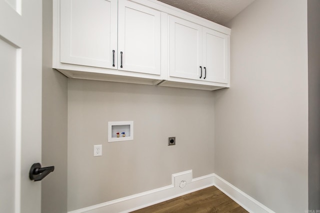 washroom featuring cabinet space, washer hookup, baseboards, hookup for an electric dryer, and dark wood-style floors
