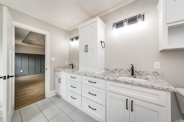 full bathroom with baseboards, double vanity, tile patterned floors, and a sink