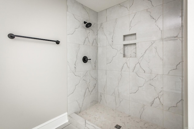 bathroom featuring a marble finish shower and baseboards