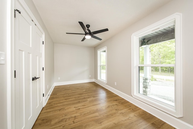 interior space featuring baseboards, ceiling fan, and light wood-style flooring