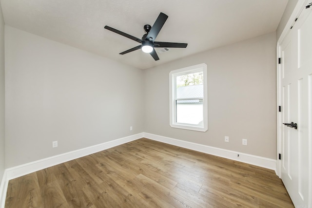 spare room with baseboards, a ceiling fan, and wood finished floors