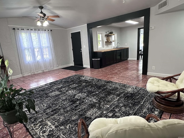tiled living room featuring a sink, plenty of natural light, a ceiling fan, and visible vents