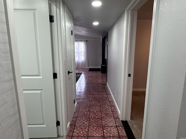 corridor with tile patterned floors, baseboards, vaulted ceiling, and recessed lighting