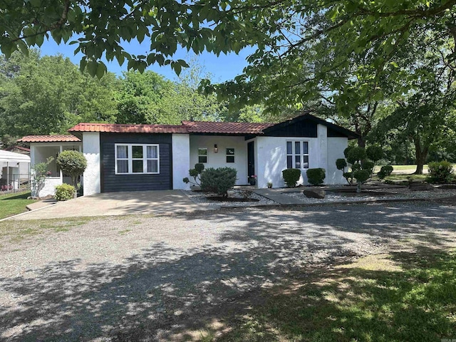 view of front of property with stucco siding and gravel driveway