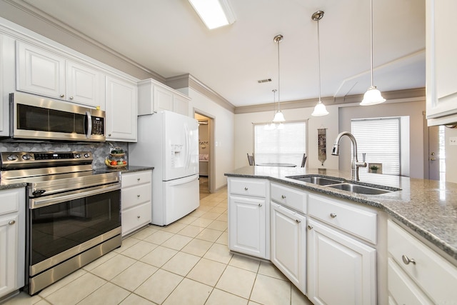 kitchen with light tile patterned flooring, a sink, stainless steel appliances, white cabinetry, and backsplash