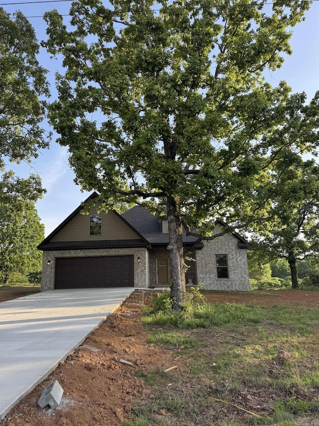 view of front of home with a garage, driveway, and brick siding