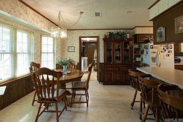 dining area with light floors, wallpapered walls, and visible vents