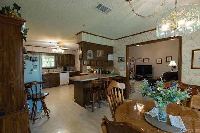 dining space featuring visible vents, crown molding, light floors, wallpapered walls, and a textured ceiling