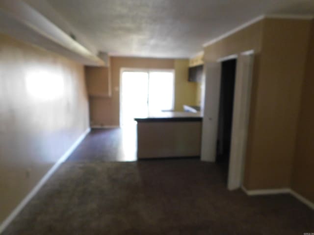 interior space with baseboards and dark colored carpet