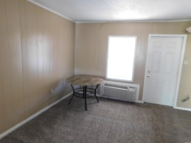 empty room with baseboards, carpet flooring, a wall mounted AC, and wood walls