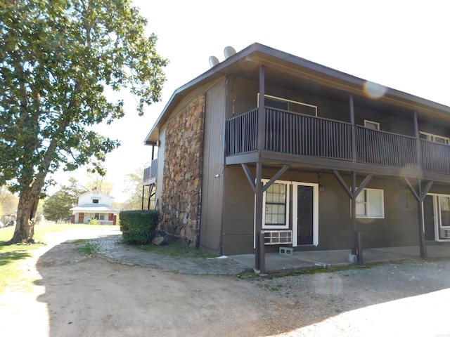 view of front of property with a balcony and stone siding