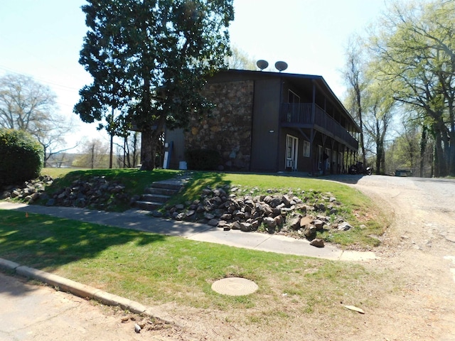 view of front of property with a front lawn and stone siding
