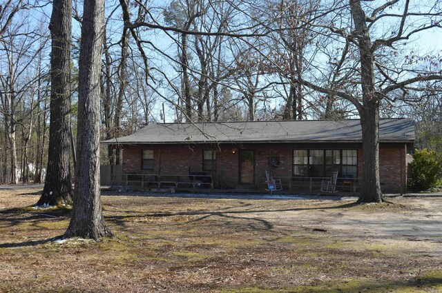 rear view of house featuring a porch and brick siding