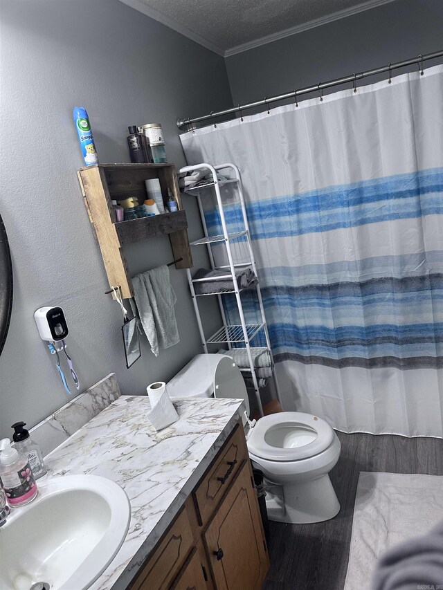full bath with a textured ceiling, wood finished floors, vanity, toilet, and ornamental molding