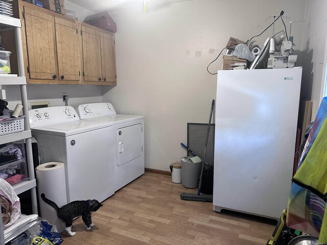 laundry room featuring cabinet space, separate washer and dryer, and light wood-style floors