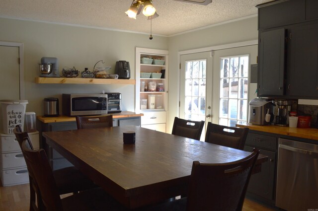dining room featuring crown molding, ceiling fan, a textured ceiling, french doors, and wood finished floors