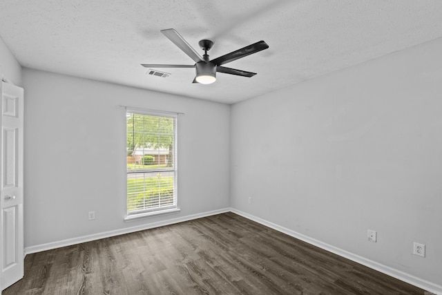 unfurnished bedroom with visible vents, baseboards, dark wood-type flooring, a textured ceiling, and a ceiling fan