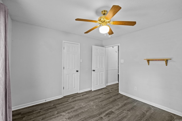 unfurnished bedroom featuring baseboards, ceiling fan, and dark wood-style flooring