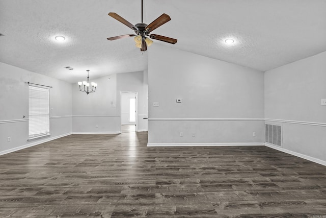 spare room featuring dark wood-style flooring, a textured ceiling, ceiling fan with notable chandelier, vaulted ceiling, and visible vents
