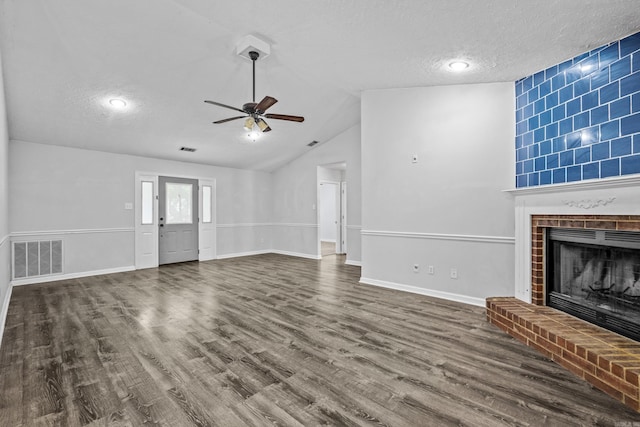 unfurnished living room with visible vents, wood finished floors, a fireplace, baseboards, and ceiling fan