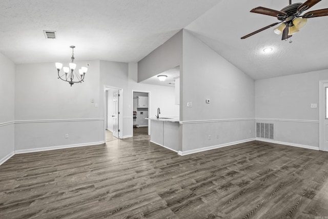 empty room with visible vents, vaulted ceiling, a sink, ceiling fan with notable chandelier, and dark wood-style floors