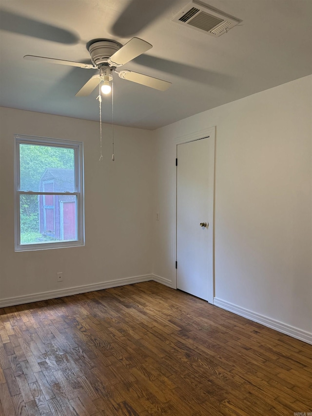 805 S St, Heber Springs, AR 72543 - empty room with visible vents, dark wood-style flooring, ceiling fan, and baseboards