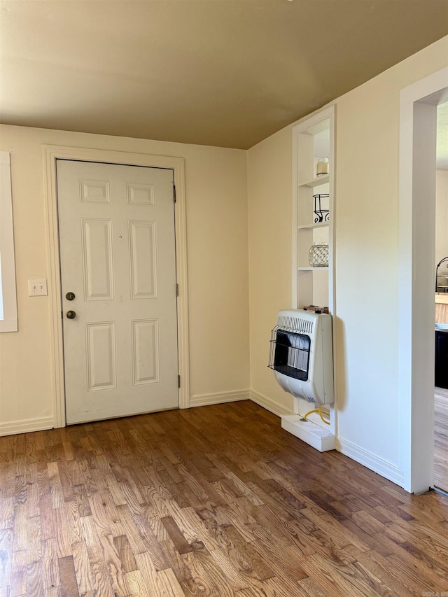 805 S St, Heber Springs, AR 72543 - entrance foyer featuring heating unit, baseboards, and wood finished floors