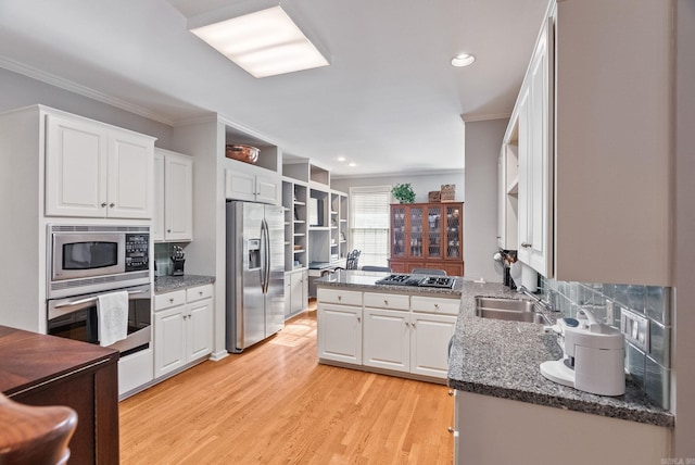 kitchen featuring crown molding, open shelves, a sink, white cabinets, and stainless steel appliances