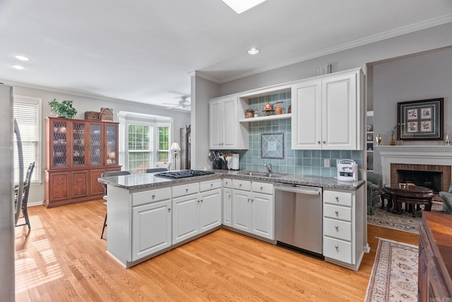 kitchen featuring white cabinets, a peninsula, gas stovetop, stainless steel dishwasher, and ornamental molding