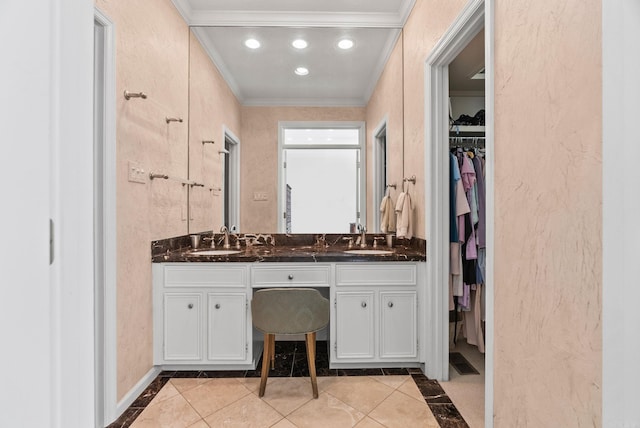 bathroom with double vanity, ornamental molding, a sink, and a spacious closet