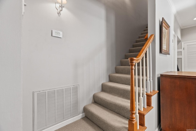 stairway featuring visible vents, carpet flooring, baseboards, and crown molding