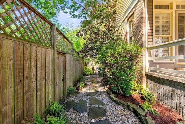 view of side of home with a garden pond and fence