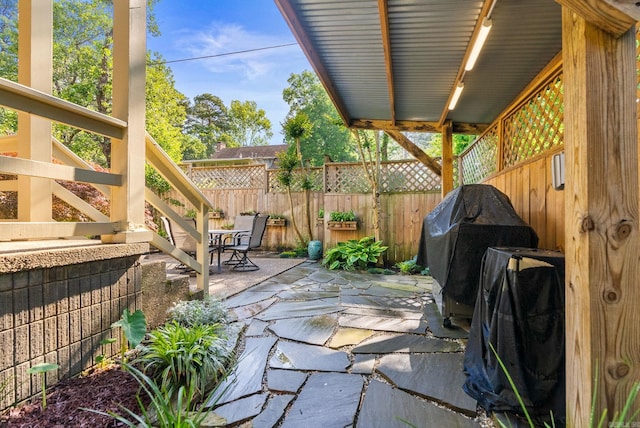 view of patio / terrace with fence and a grill