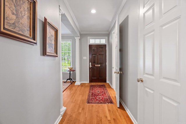 doorway to outside with ornamental molding, light wood-style floors, baseboards, ornate columns, and recessed lighting
