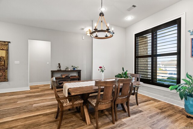 dining area with light wood-style floors, baseboards, a chandelier, and visible vents