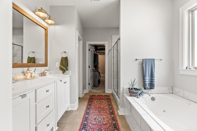 bathroom with a jetted tub, vanity, a stall shower, and tile patterned floors