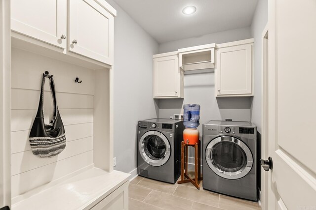 washroom with separate washer and dryer, baseboards, light tile patterned flooring, and cabinet space