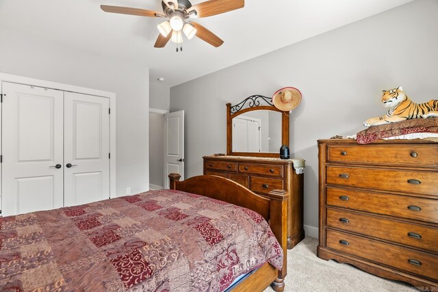 bedroom featuring a ceiling fan, light carpet, and a closet